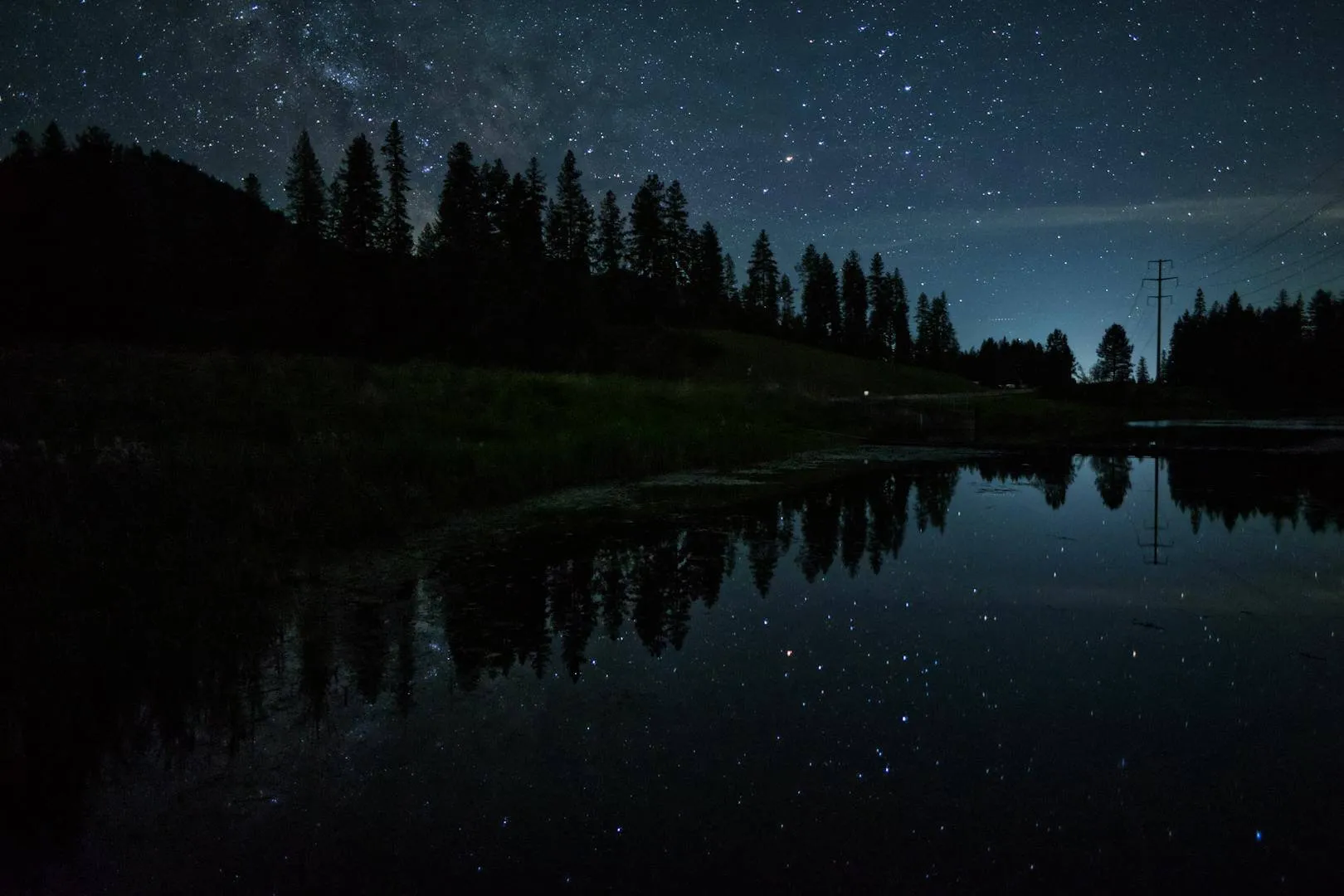 Imagen de un lago reflejando las estrellas